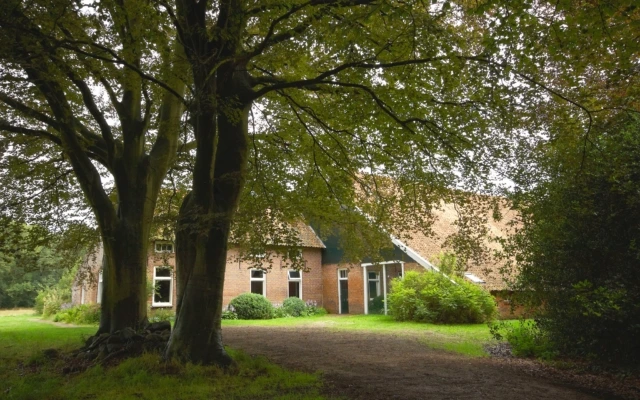 Historische boerderij tussen monumentale bomen